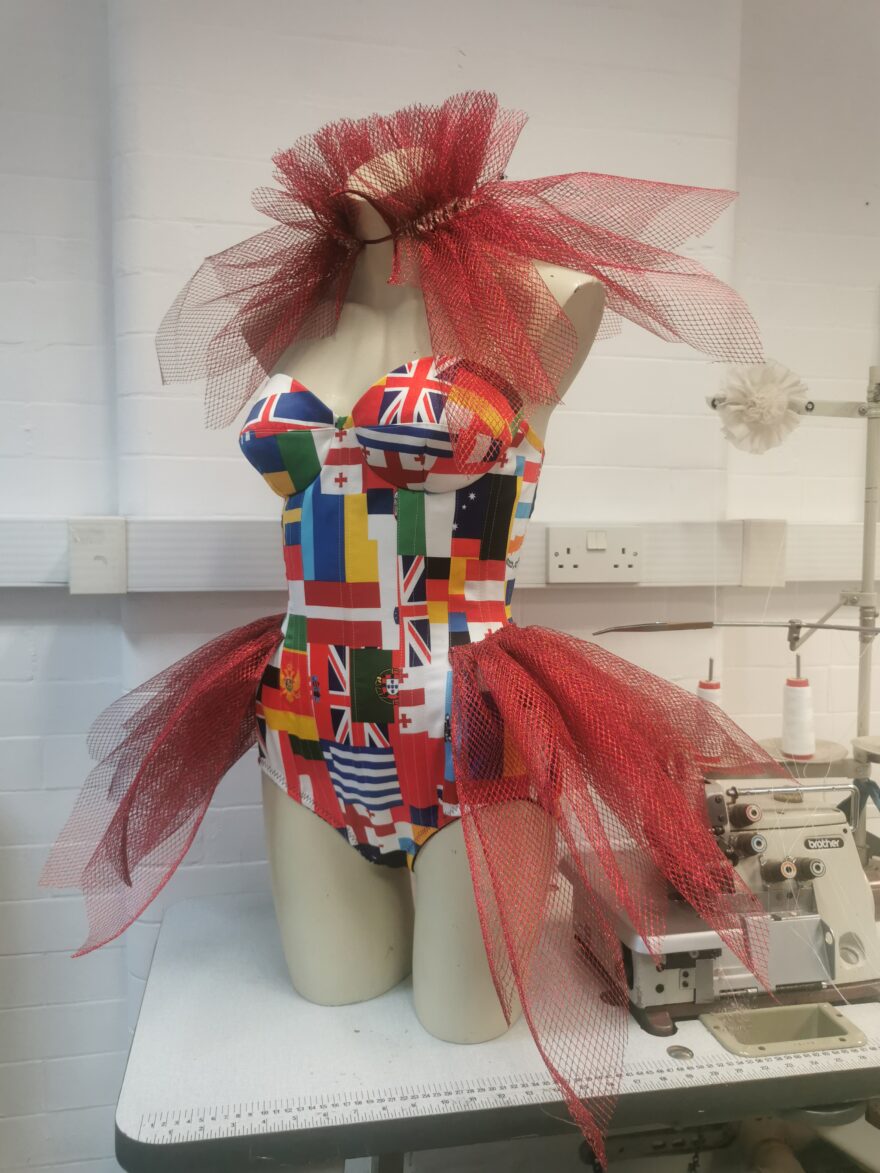 Custom Eurovision flags printed satin cupped corset with dramatic red spikey hip flares and ruff collar